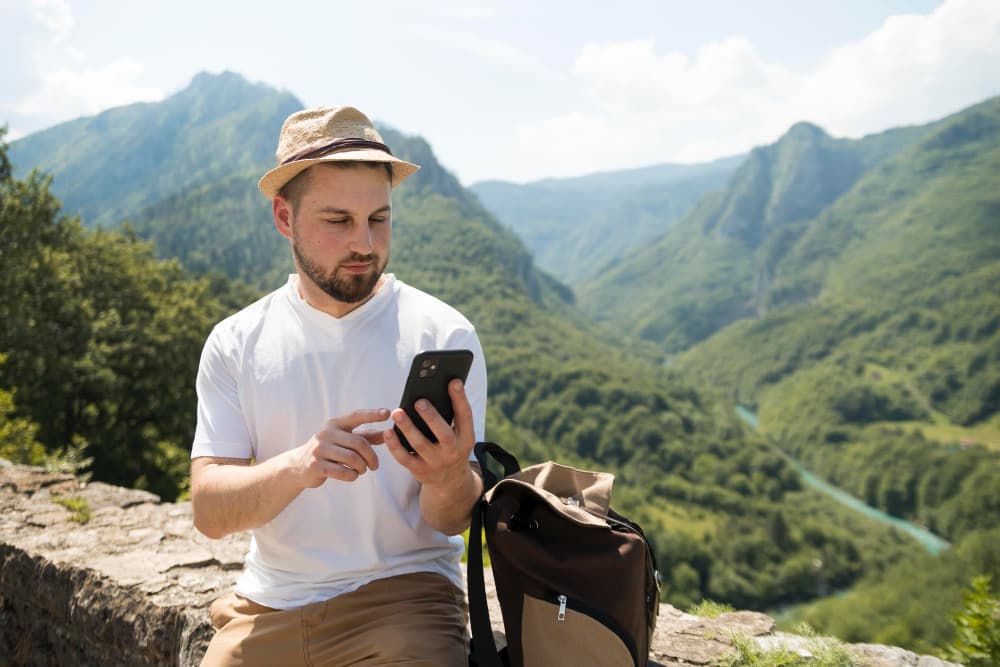 Traveler checking his phone outdoors before transferring an eSIM between devices
