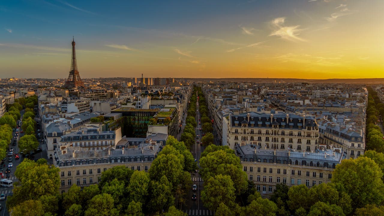 Eiffel Tower rising above Paris rooftops at sunset