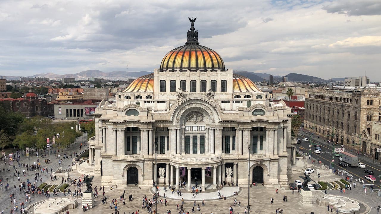 Palacio de Bellas Artes cultural center in downtown Mexico City with its ornate domed roof and Beaux-Arts façade against a cloudy sky