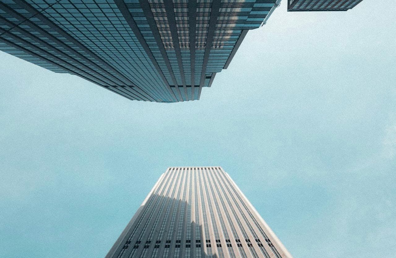 Looking up at glass skyscrapers against a clear sky