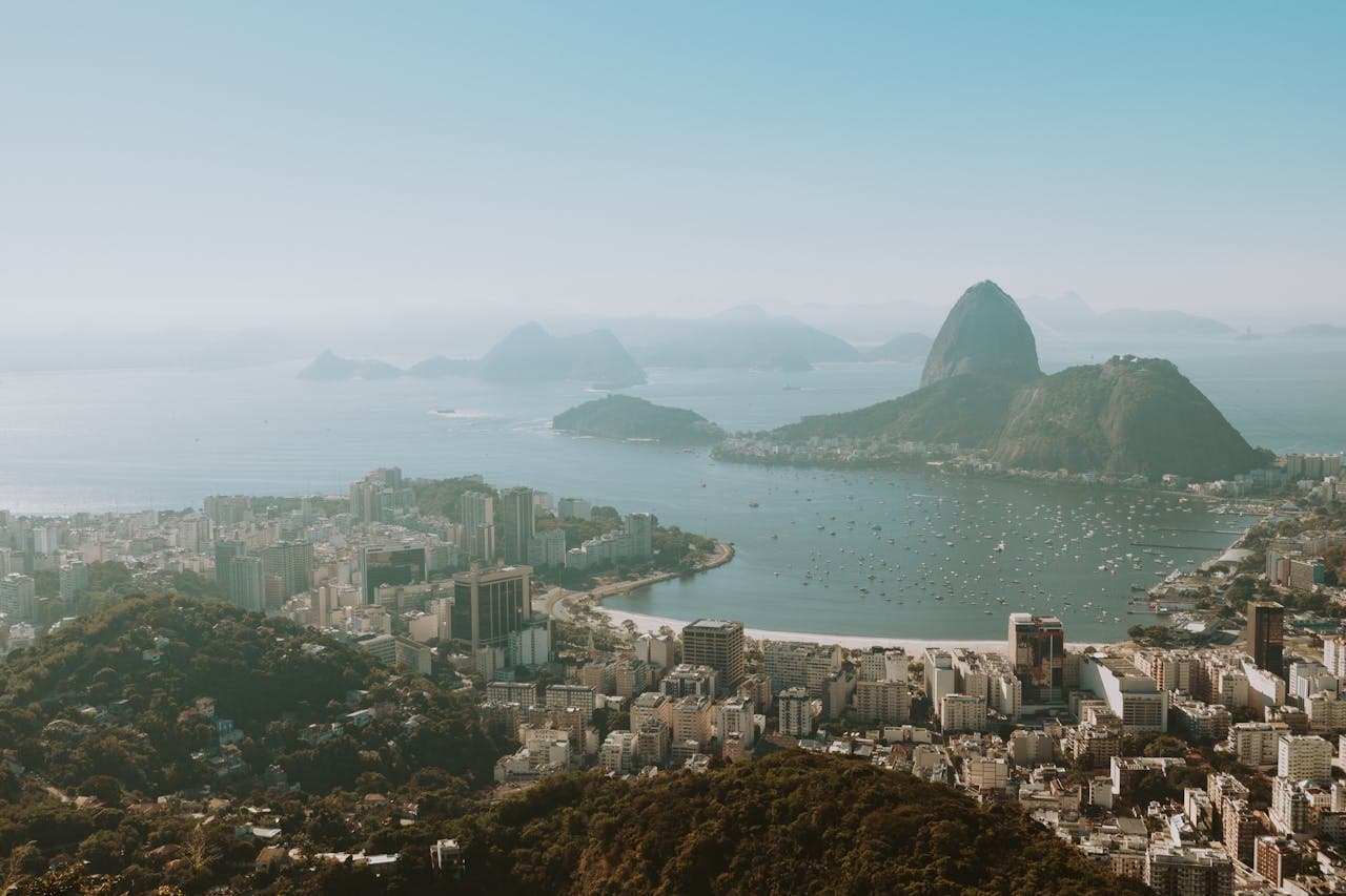 Scenic view of Sugarloaf Mountain and Guanabara Bay with boats and city buildings in Rio de Janeiro on a sunny day