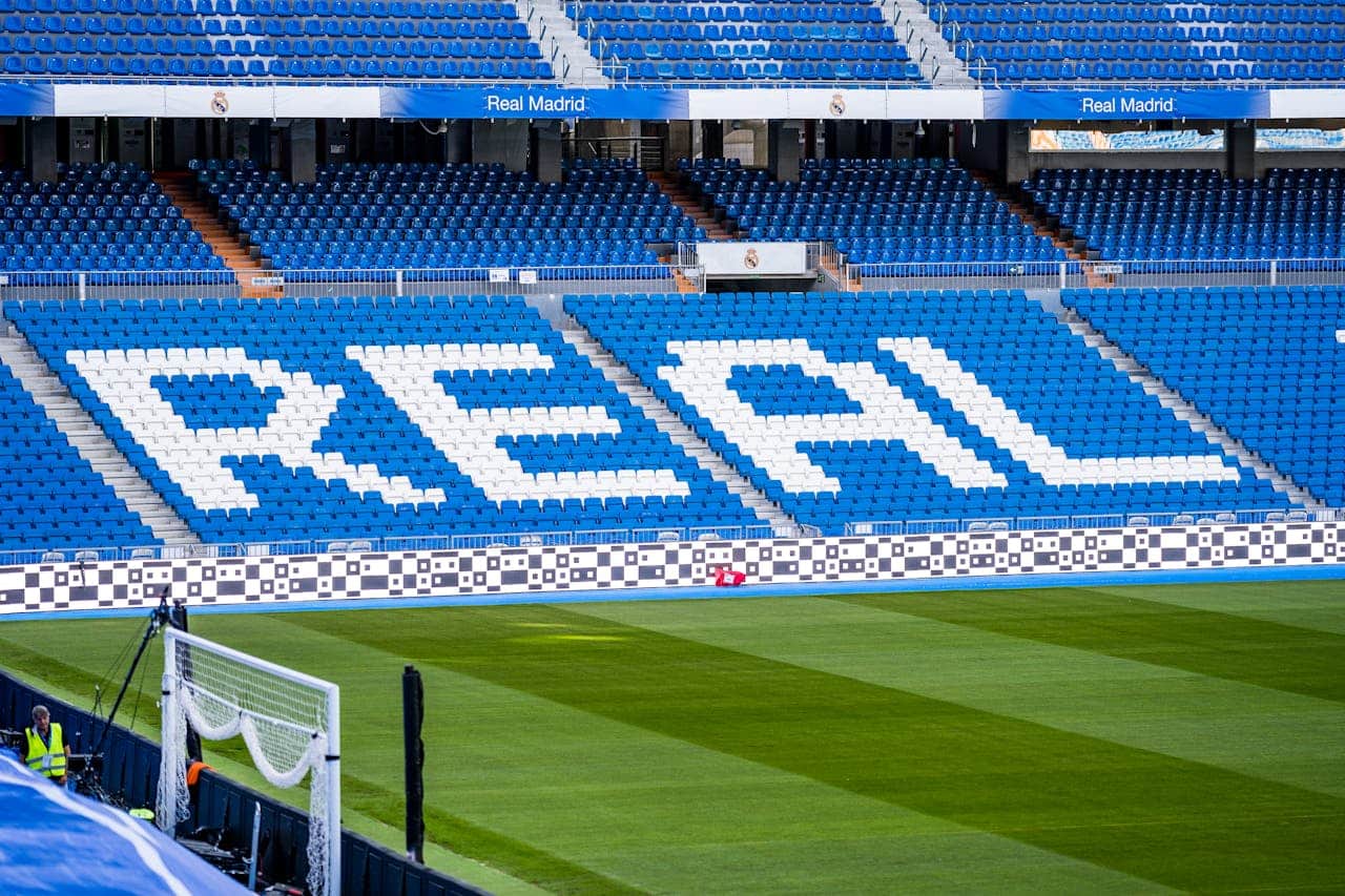 Real Madrid stadium seats with the word "REAL" displayed in white on blue chairs at Santiago Bernabéu Stadium.