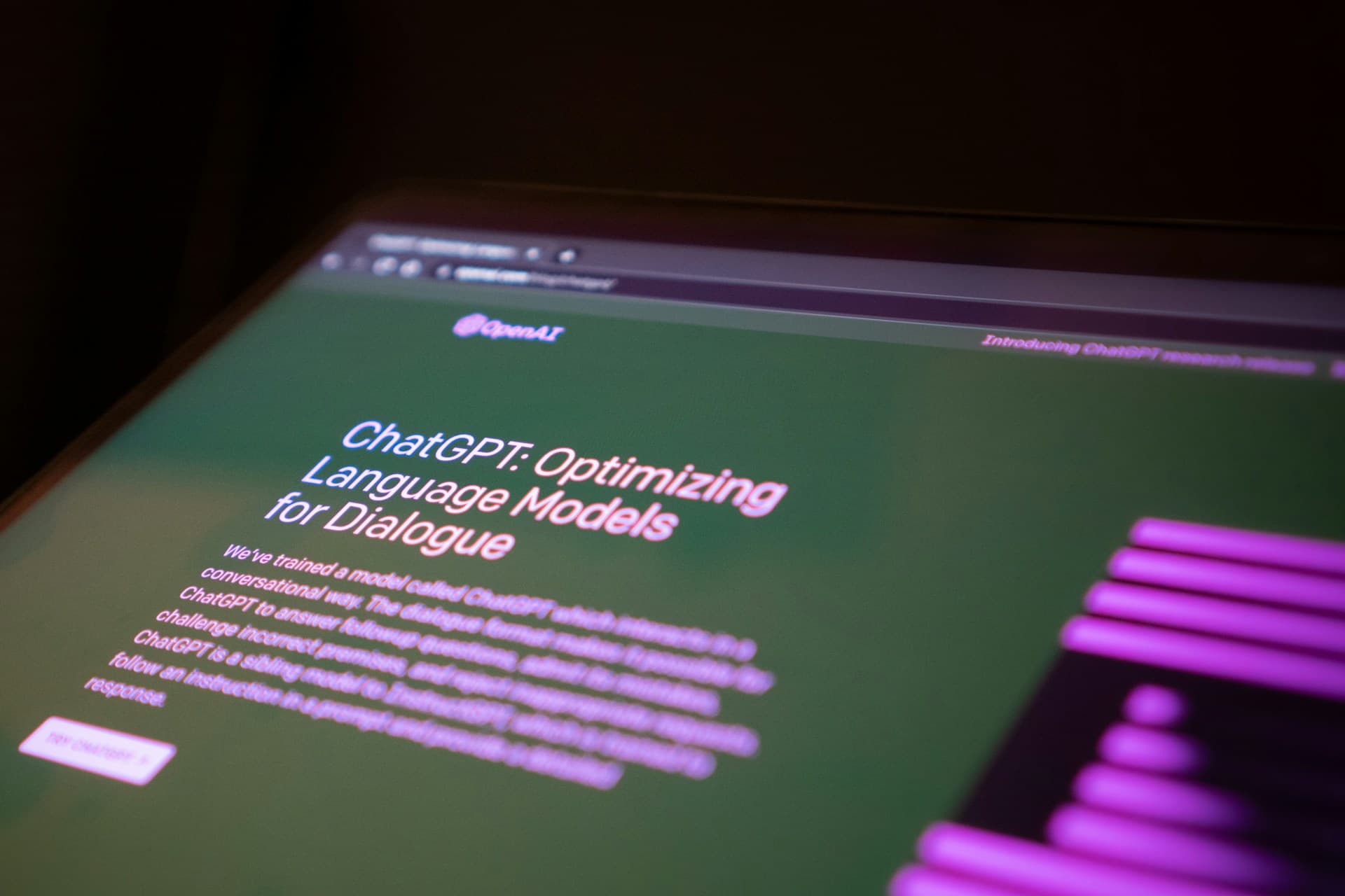 Laptop screen displaying a website about ChatGPT, featuring information on optimizing language models for dialogue on a green background.