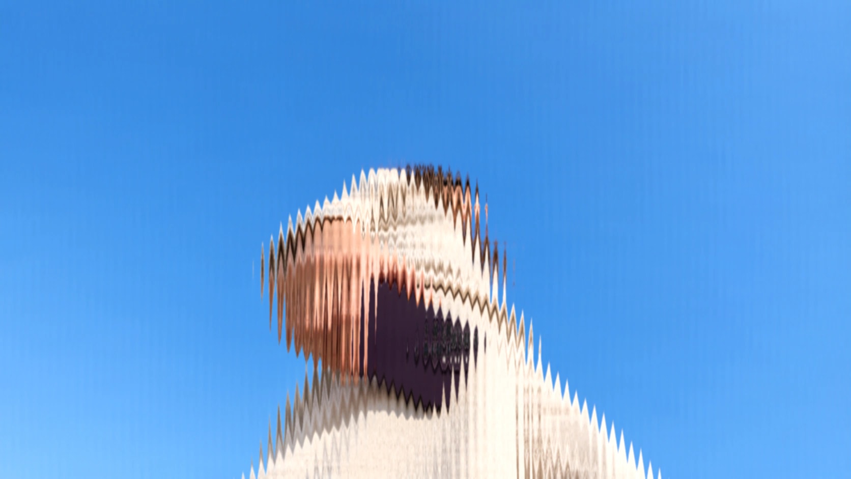 Person holding a phone against a deep blue sky, blurred by a pixel-smear effect