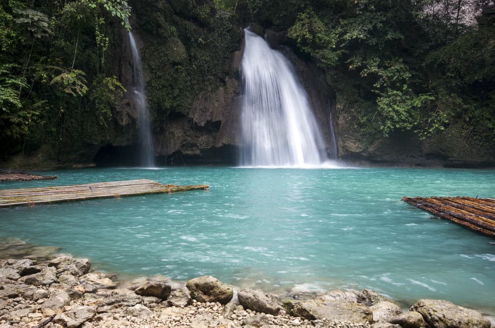Water fall that lands on a very blue lake.