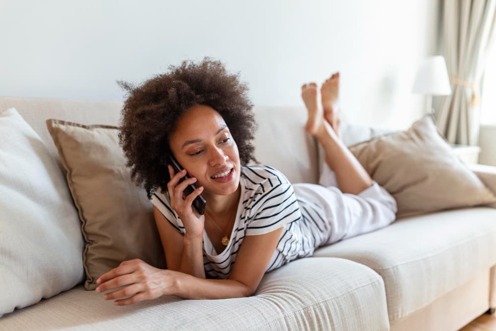 Woman relaxing on a couch while making a phone call