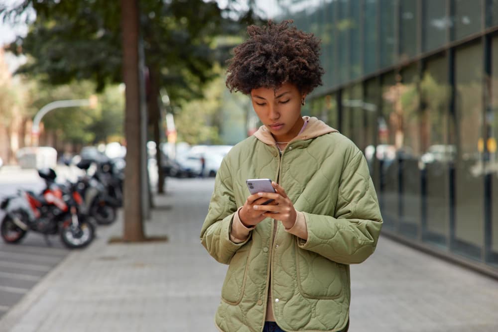 Person checking their phone on a city street