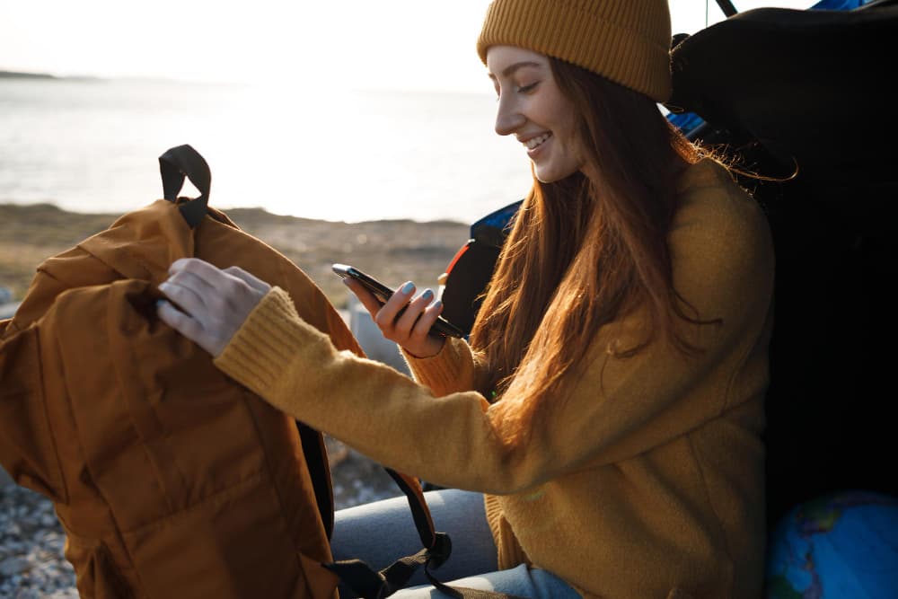A woman in Portugal utilizing Firsty, smiling at the fact that she has connection wherever she goes on her trip.