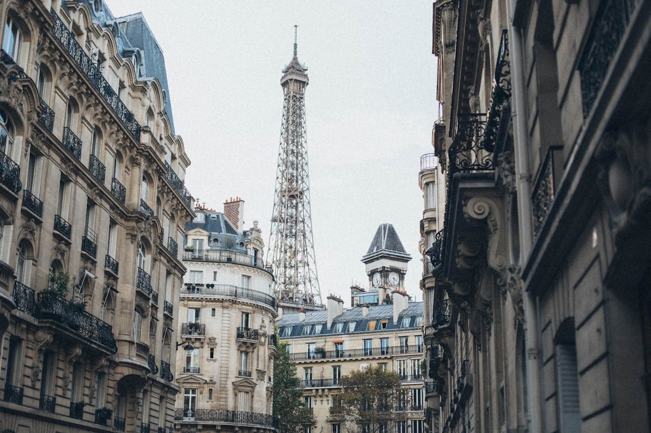 View of streets in Paris with direct view of the Eiffel Tower over the buildings.