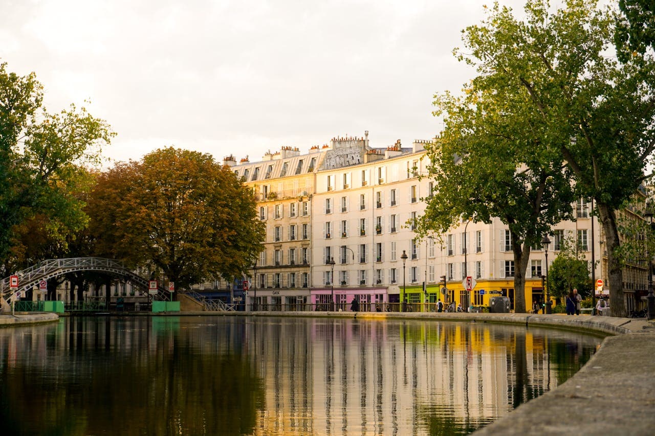 View of a Parisian canal. The house have colourful shops on the bottom floor,