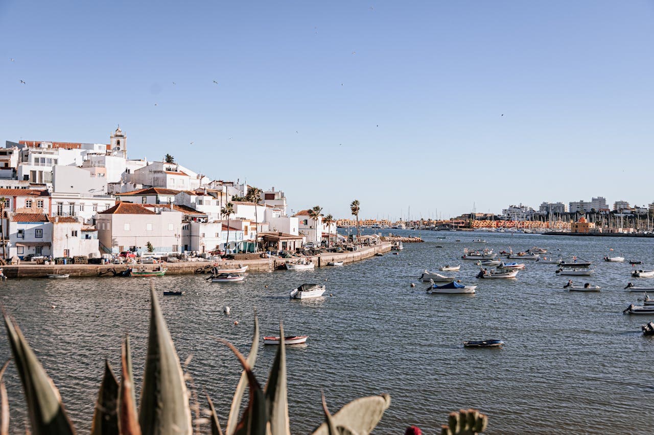 The marina of the portuguese city of Faro, with view of the bay with small boats and white houses at the water line.