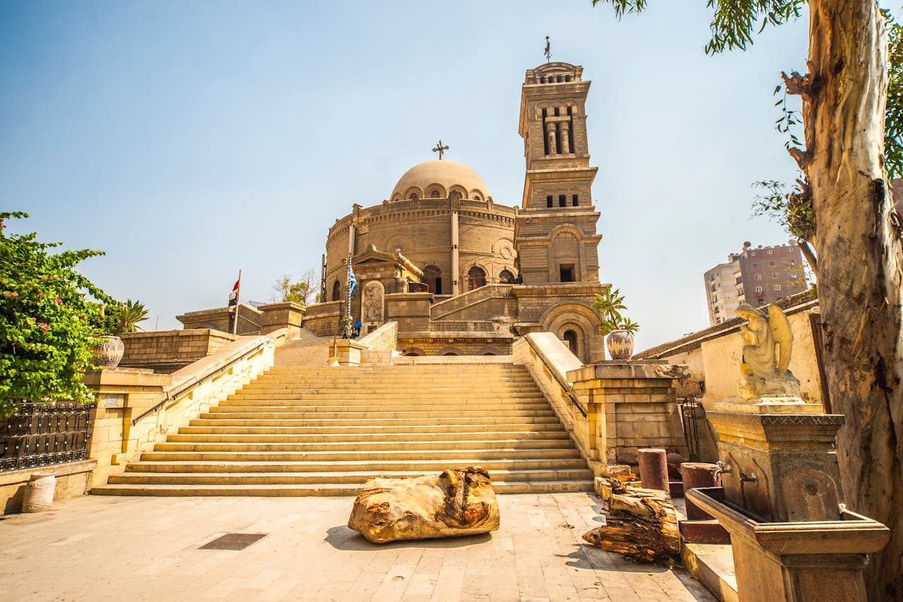 Historic Saint George Greek Orthodox Church in Cairo, Egypt, with grand stone staircase and architectural details under a clear sky