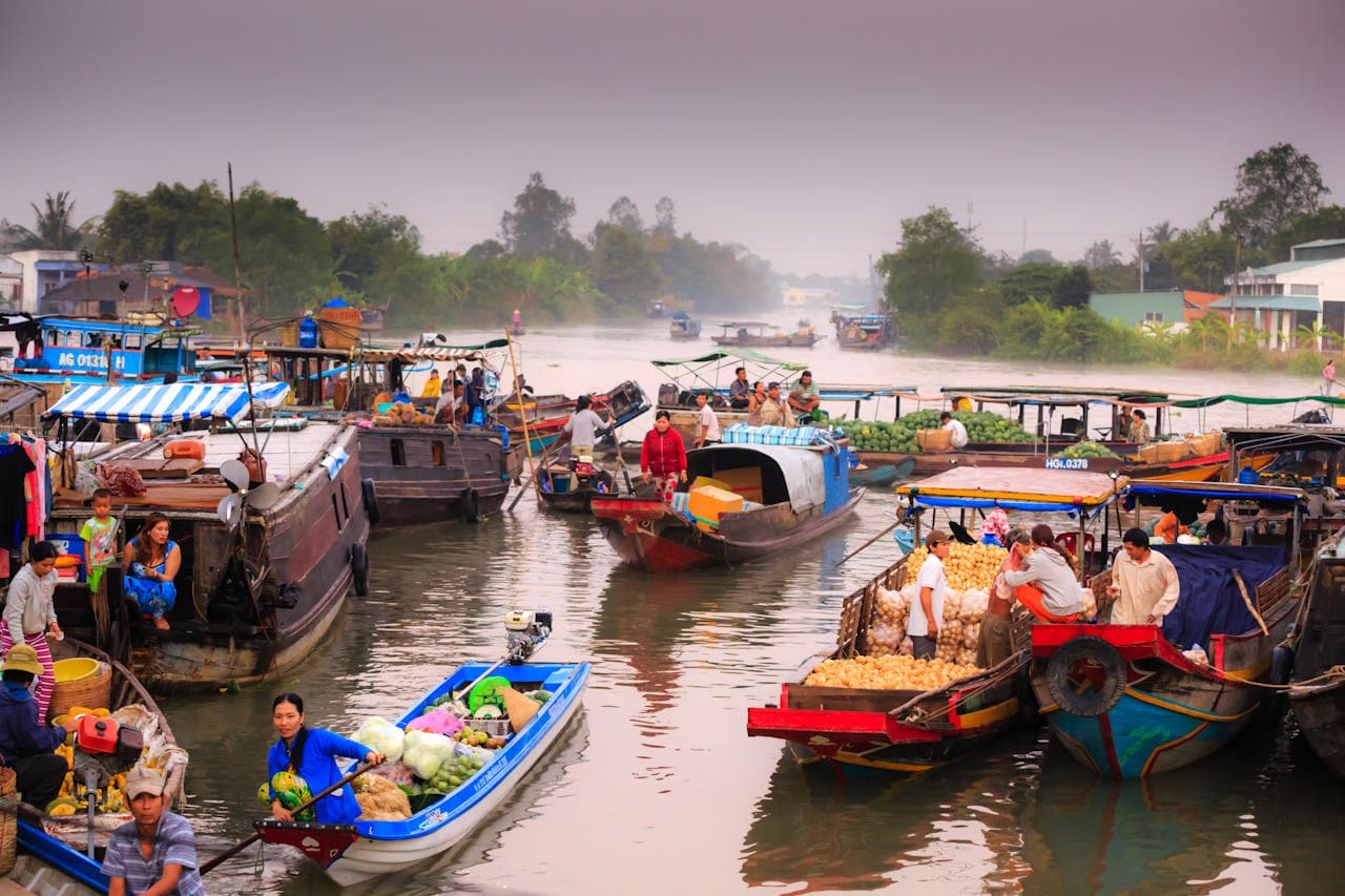 Vibrant floating market in the Mekong Delta, Vietnam, with boats filled with fresh produce and local vendors engaging in trade on the river.