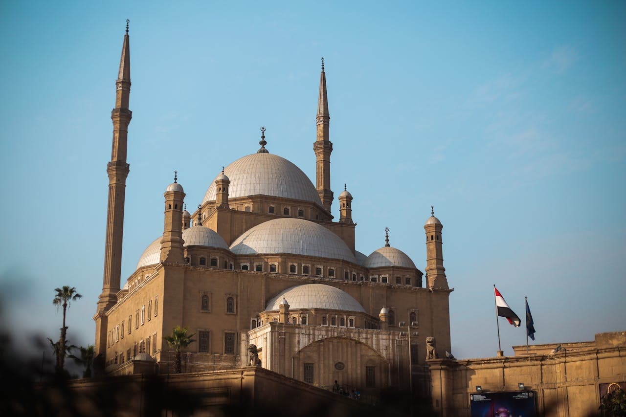 Exterior view of the historic Mosque of Muhammad Ali with its grand domes and minarets in Cairo, Egypt.
