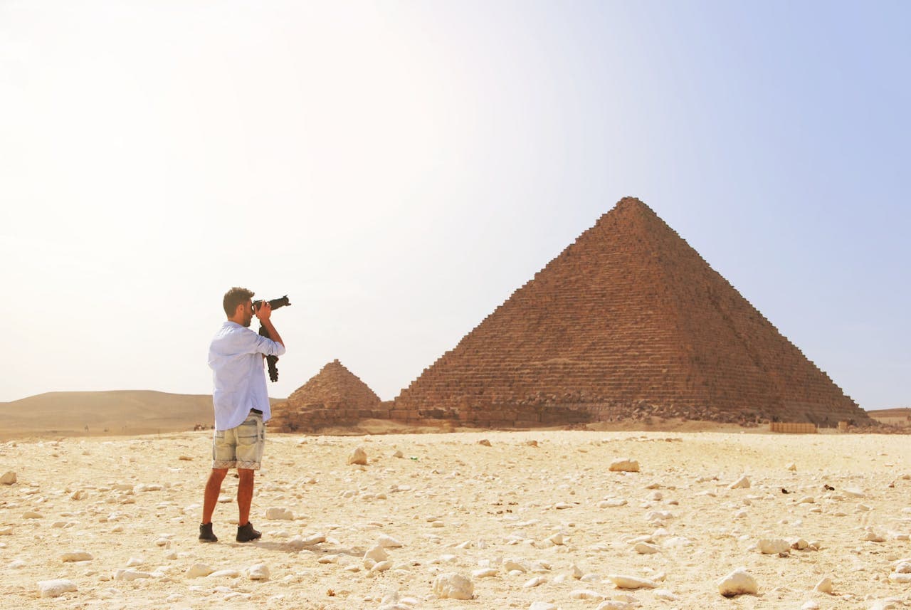 Tourist staying connected with Firsty eSIM while taking pictures of the giza pyramids in Cairo, Egypt.