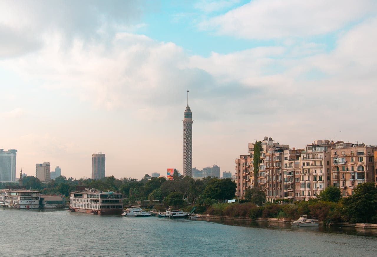 View of the Cairo skyline with the iconic Cairo Tower overlooking the Nile River on a partly cloudy day