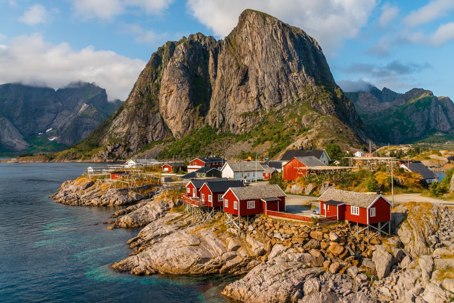 Red fishing cabins beneath a mountain peak in the Lofoten Islands, Norway