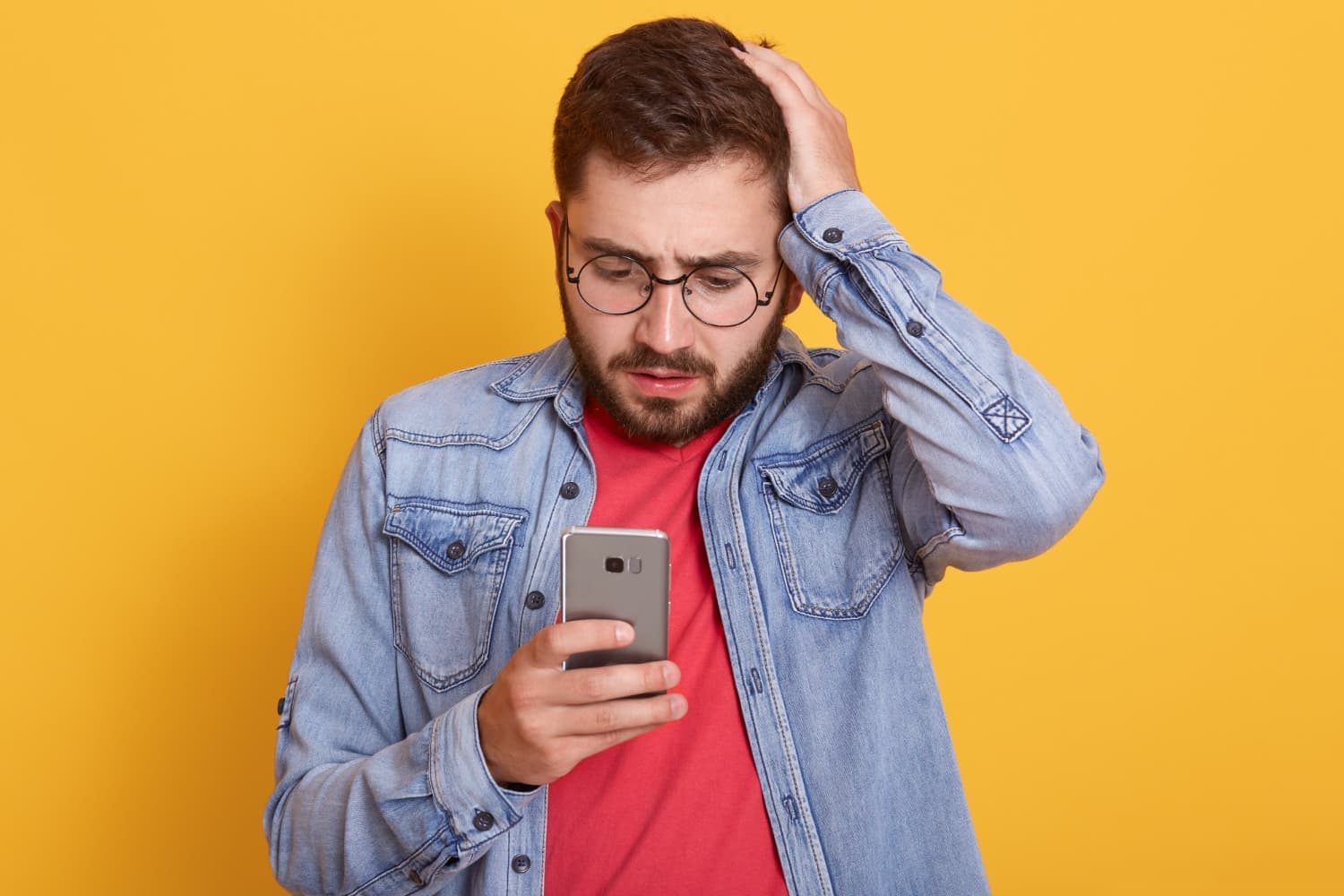 Man looking worried at his phone after realising he has lost it