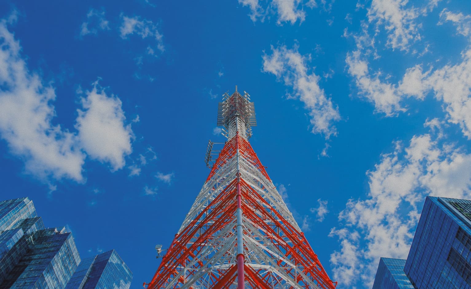 Cell tower rising above city buildings