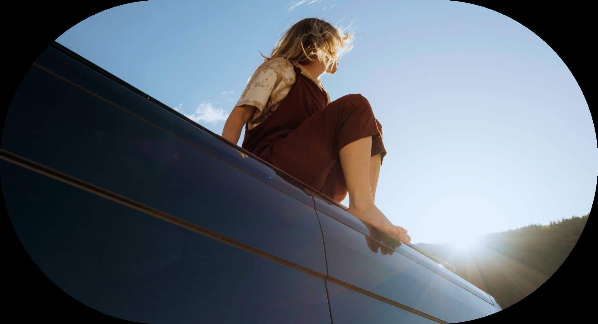Person sitting on a car roof at sunset for Firsty's international calling relaunch
