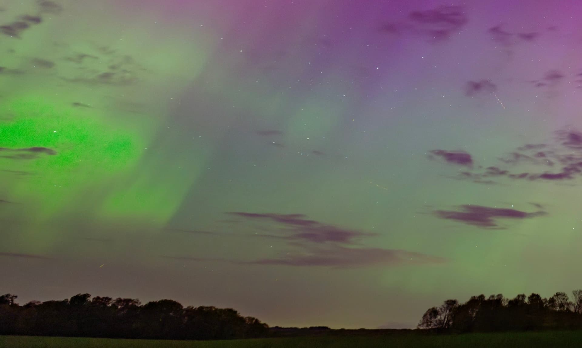Green and purple northern lights over fields in Pennsylvania