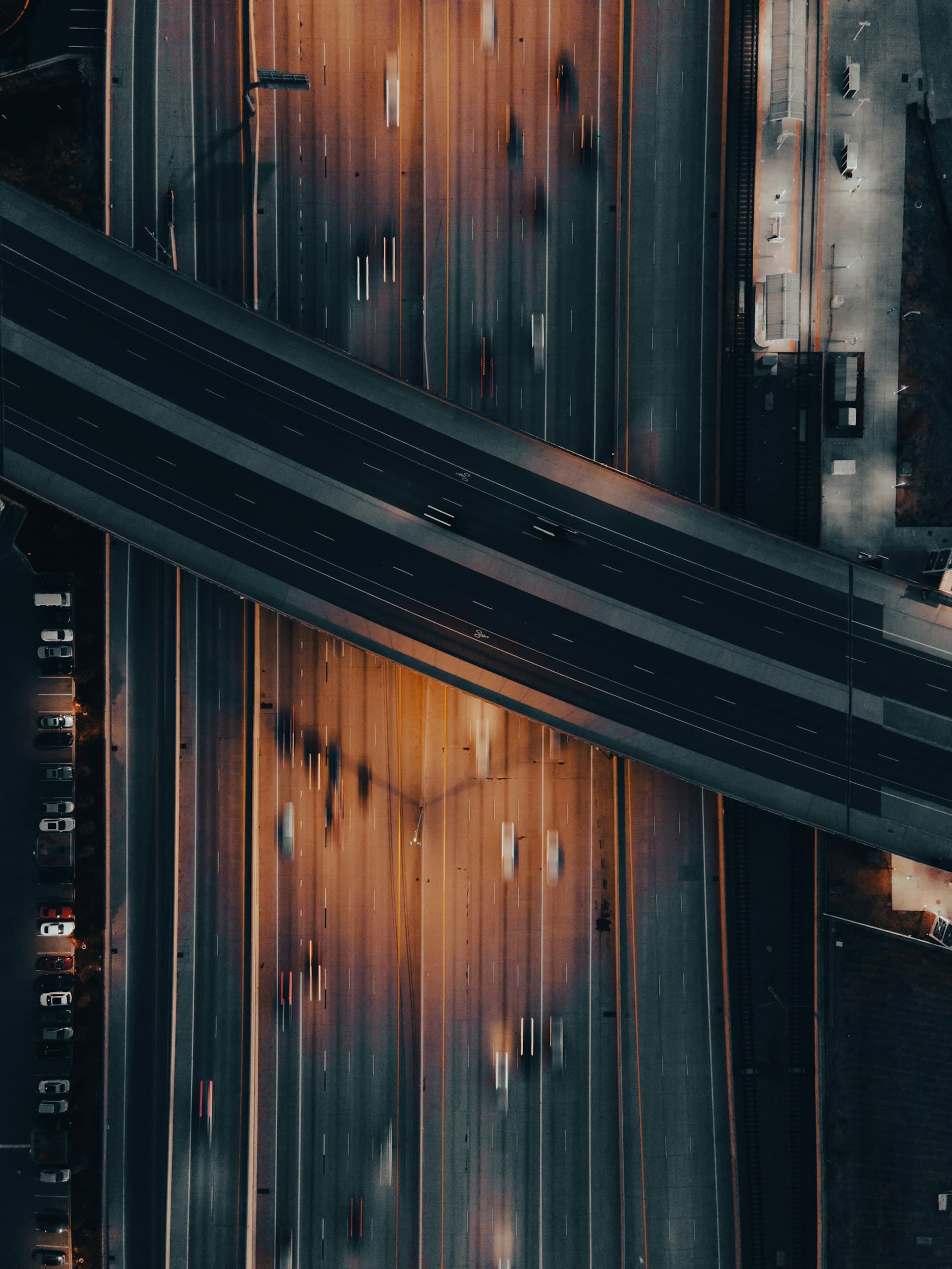 Aerial night view of a highway interchange with motion-blurred traffic, representing global connectivity infrastructure for ride-hailing platforms