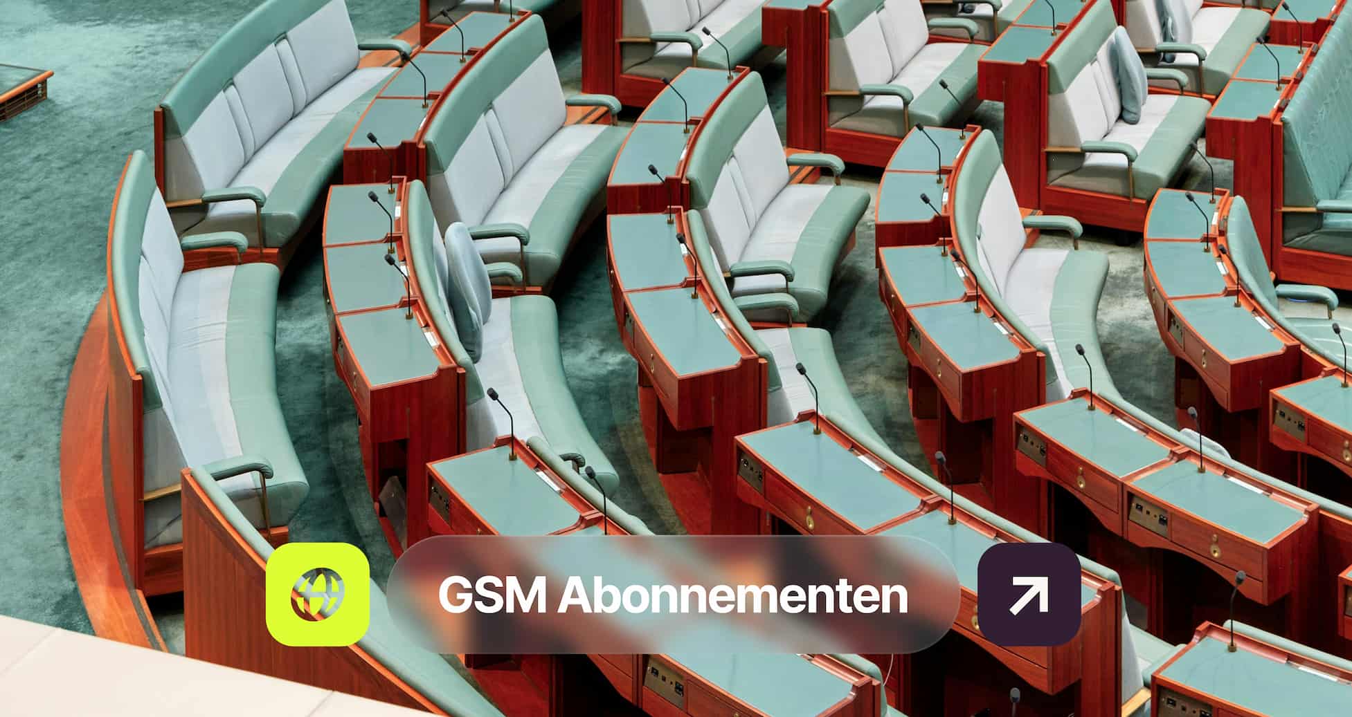 Rows of empty green chairs and wooden desks in a parliamentary assembly hall, with microphones and a "GSM Abonnementen" overlay at the bottom.
