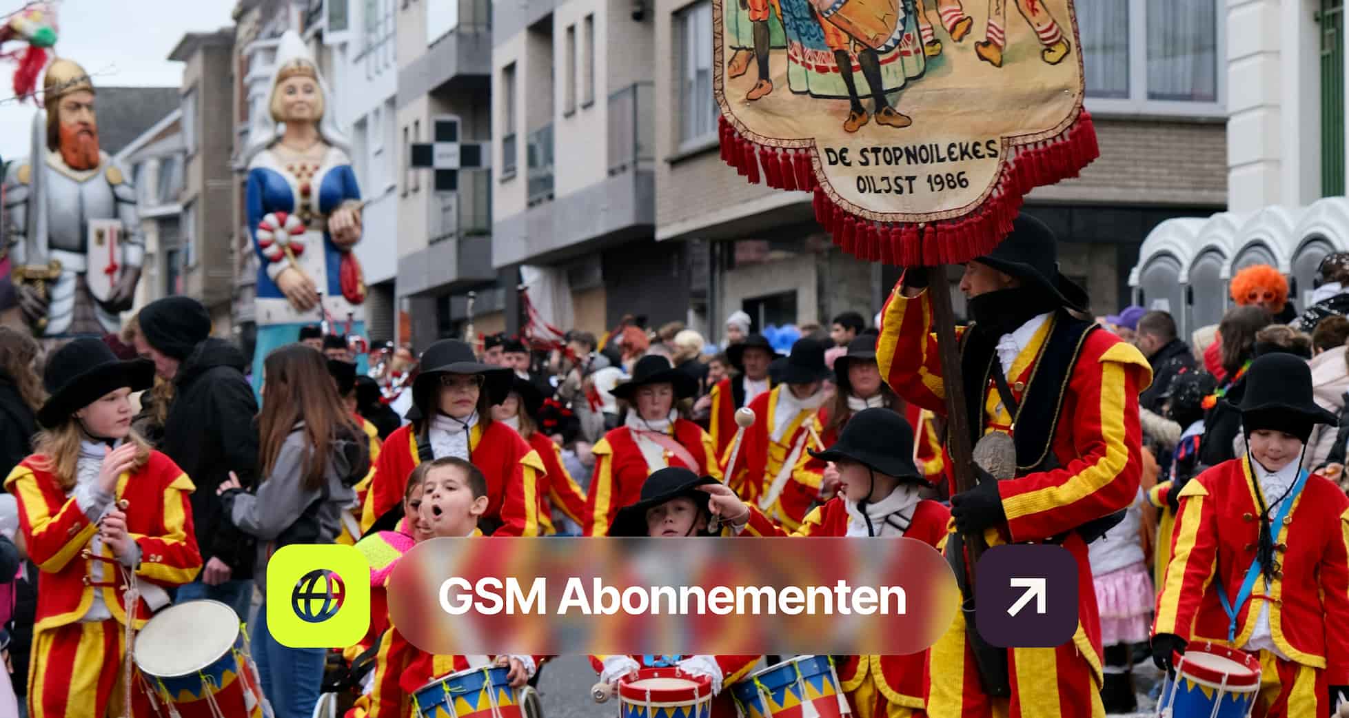 A parade with people in red and yellow costumes, some playing drums. Large figures in the background, and a banner saying "De Stopenoilekes."
