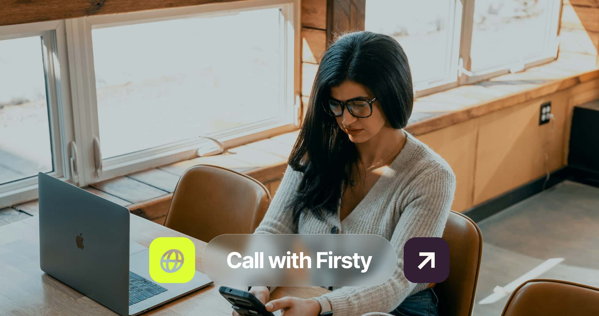 A person sitting at a table using a smartphone, with a laptop open beside them and a text overlay saying "Call with Firsty."