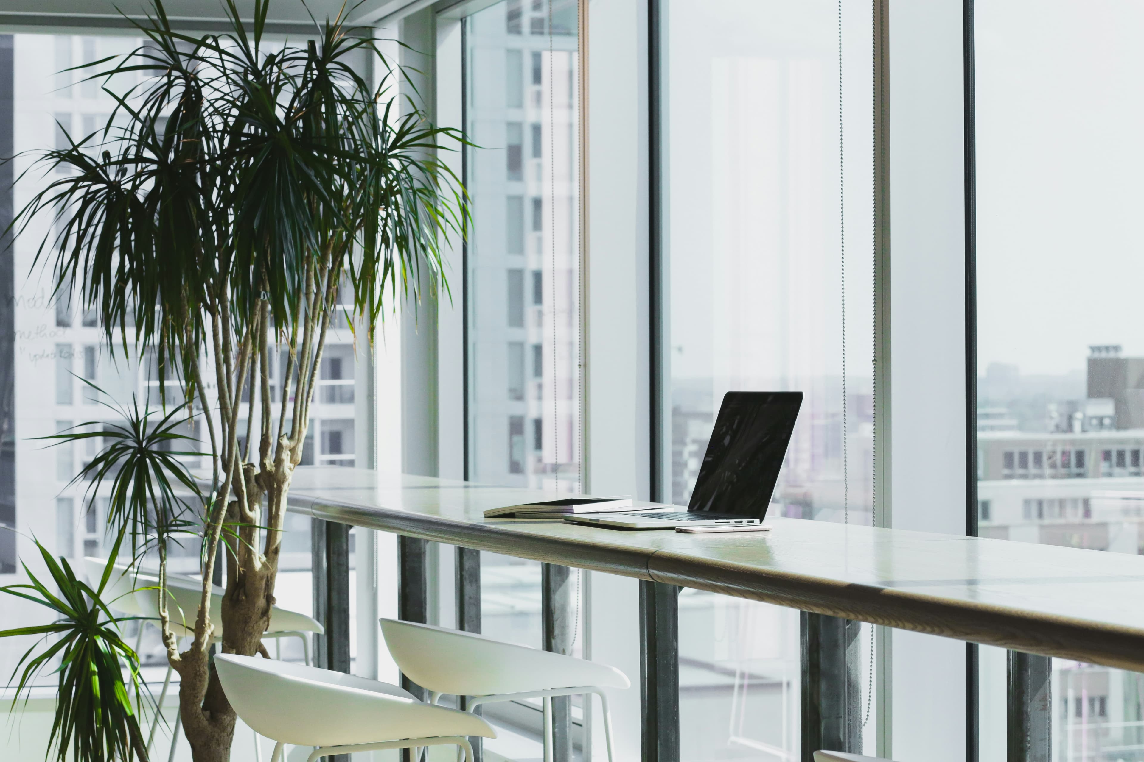 Laptop on a desk in a bright office overlooking the city