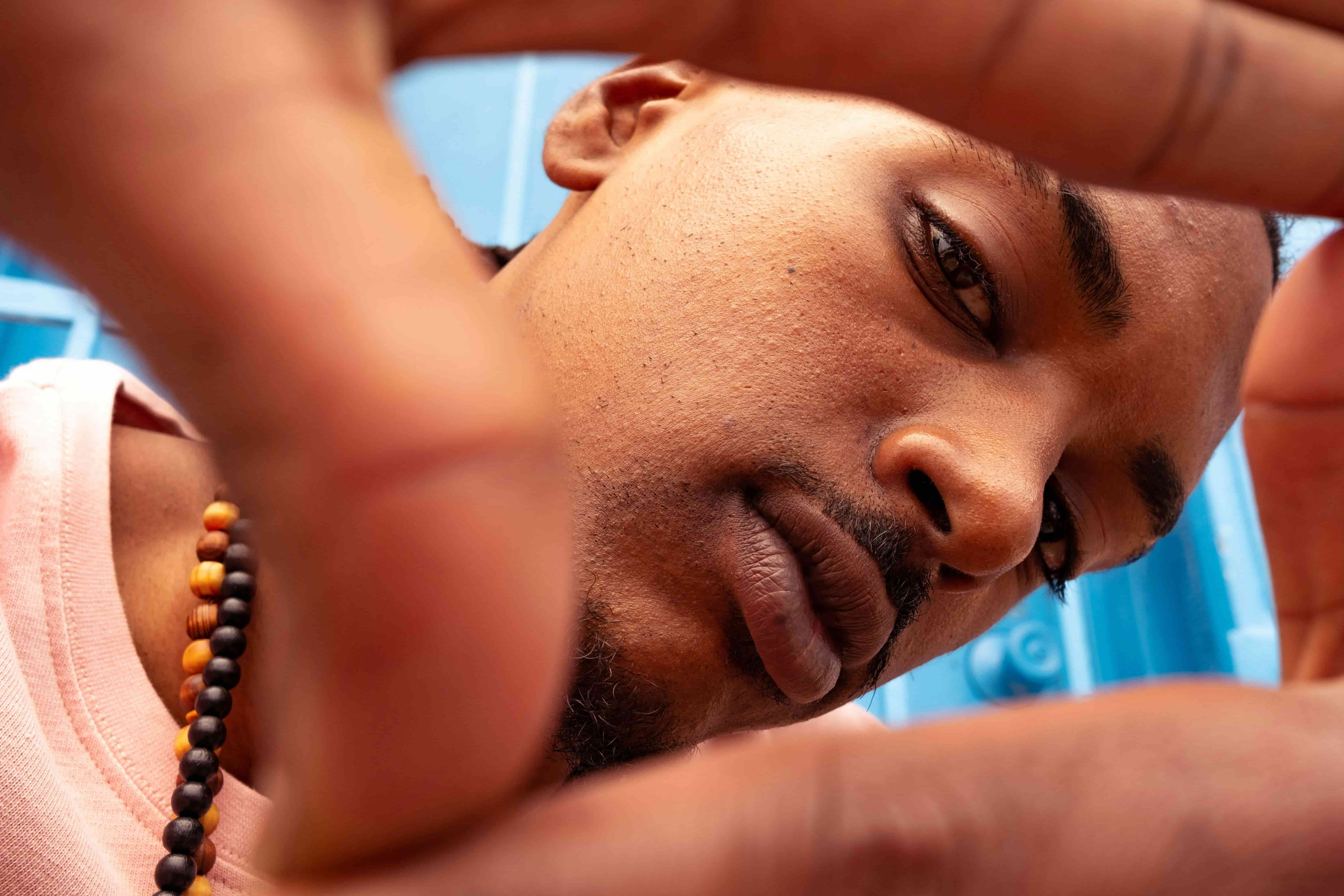 Close-up of a man framing a shot with his hands outdoors